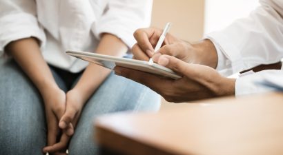 Healthcare medical concept, Doctor psychiatrist consulting gynecological female illness, use pointing tablet monitor for Explain to patient. Physician wearing Stethoscope on neck for treating hospital